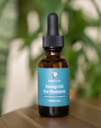 front of brown lolahemp hemp oil for humans bottle with blue label on wooden table with plants in the background